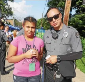  ??  ?? Kennett Township Ptl. M. Juarez and Yasdamy Bautista compare their favorite foods and colors during National Night Out Tuesday in Kennett Square.