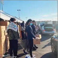  ?? David Borges / Hearst Connecticu­t Media ?? UConn men’s basketball players help distribute groceries at a Foodshare-sponsored food drive on Thursday morning at Rentschler Field.