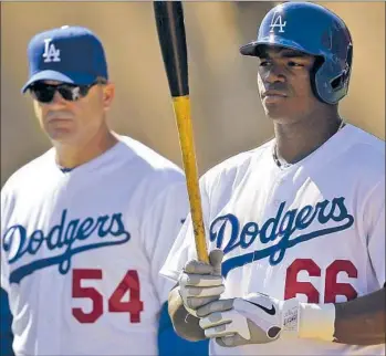  ?? Luis Sinco Los Angeles Times ?? THE DODGERS made a splashy reentry in the Latin American market when they signed Yasiel Puig, then 21, last year; 41-year-old fellow Cuban Eddie Oropesa, left, was hired to ease his transition to the U.S.