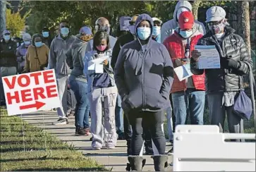  ?? Gerry Broome Associated Press ?? EARLY VOTE CENTERS in North Carolina opened Thursday with some people waiting two hours to cast their ballots. Above, voters line up at the South Regional Library polling location in Durham, N. C.