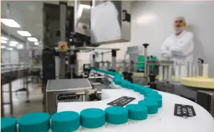  ?? (Ronen Zvulun/Reuters) ?? A TEVA employee watches pill bottles on a conveyor belt at the company’s Jerusalem plant.