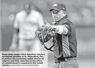  ?? CHRIS O’MEARA/THE ASSOCIATED PRESS ?? Home plate umpire Chris Guccione sports a wristband Saturday in St. Petersburg, Fla., to protest the escalating verbal attacks on umpires and their objection to the office of commission­er’s response to the verbal attacks.