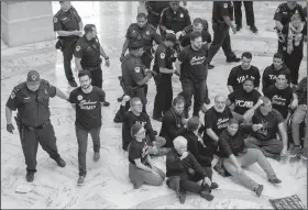  ?? AP/J. SCOTT APPLEWHITE ?? Activists opposed to President Donald Trump’s embattled Supreme Court nominee, Brett Kavanaugh, are arrested on Capitol Hill on Monday in Washington. nwadg.com/ national/