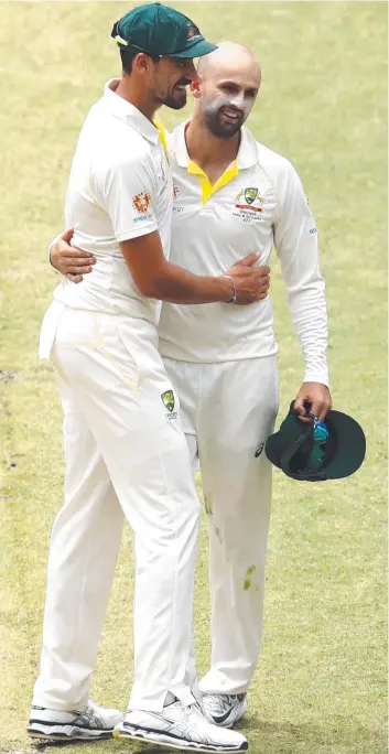  ??  ?? Mitchell Starc congratula­tes Nathan Lyon on taking five wickets during day three of the second match in the Test series against India