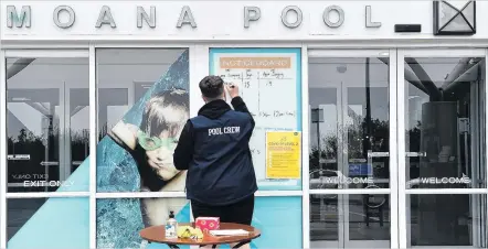  ?? PHOTOS: PETER MCINTOSH ?? Signs of the times . . . Moana Pool crew member Mark Lieshout prepares the pool’s entry yesterday as the South Island went into Covid19 Alert Level 2 from midnight last Sunday. Right: Some essential Covid reading at the Dunedin Public Library. Below left: Esther Paterson dons a compulsory face mask for public transport travel at the Bus Hub in Dunedin. Right: Bus driver Palitha Udamulla.