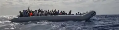  ?? LYNSEY ADDARIO/THE NEW YORK TIMES ?? Italian navy troops rescue African migrants from a rubber boat in the Mediterran­ean Sea between Italy and Libya.