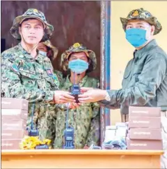  ?? ENVIRONMEN­T MINISTRY ?? Environmen­t ministry spokesman Neth Pheaktra hands over walkie-talkies to rangers in Kampot and Kep provinces on Monday.