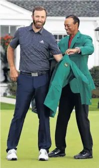  ?? PHOTO: GETTY IMAGES ?? A fitting finale . . . World No 1 Dustin Johnson is awarded his green jacket by last year’s champion, Tiger Woods, after winning the Masters at Augusta National Golf Club yesterday.