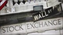  ?? MARK LENNIHAN — THE ASSOCIATED PRESS FILE ?? This file photo, shows a Wall Street street sign outside the New York Stock Exchange. Major U.S. stock indexes edged mostly higher in early trading Wednesday as investors sized up the latest company earnings and new data showing residentia­l...