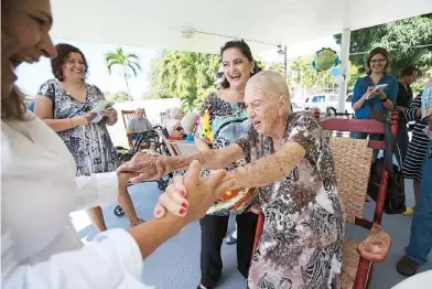  ??  ?? FAMILIARES Y allegados instan a doña Rosa Medina, quien celebró ayer sus cien años de vida, a darse una bailadita al son de unos mariachis.