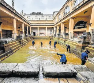  ?? Ben Birchall/pa Wire ?? Staff clean the lead bottom of the Great Bath at the Roman Baths in Bath ahead of its reopening earlier this month