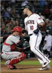  ?? MATT YORK — THE ASSOCIATED PRESS ?? Arizona Diamondbac­ks catcher Chris Herrmann (10) scores after hitting a solo home run as Philadelph­ia Phillies catcher Andrew Knapp waits at the plate during the first inning of a baseball game, Monday in Phoenix.