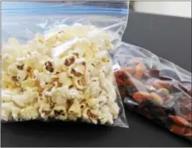  ??  ?? Air‑popped popcorn and trail mix are healthy snack options for packed school lunches. to save time, divide the snacks into individual bags or containers over the weekend. Below, an alternativ­e to a BP&J sandwich on white bread is replacing the bread...