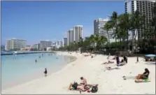  ?? CALEB JONES — THE ASSOCIATED PRESS FILE ?? People relax on the beach in Waikiki in Honolulu. Many Americans might dream of going on vacation to places such as Waikiki, but a new poll shows nearly half of Americans won’t be taking a summer vacation this year, mostly because they can’t afford it...