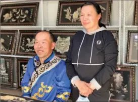  ??  ?? Sun Yulin, a representa­tive inheritor of Hezhe fishskin art from Heilongjia­ng province, and his wife pose with their works.