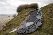  ?? MICHEL SPINGLER / ASSOCIATED PRESS ?? A damaged inflatable small boat lays discarded on the shore in Wimereux, northern France, on Thursday in Calais, northern France.