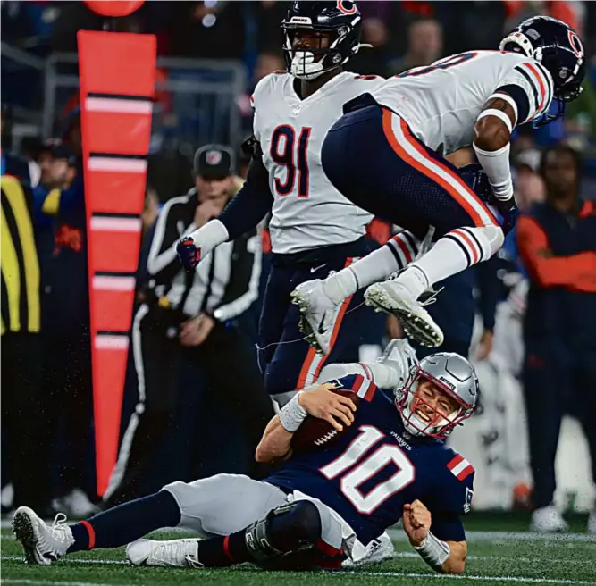  ?? JIM DAVIS/GLOBE STAFF ?? Patriots quarterbac­k Mac Jones, surprising­ly mobile as he got the start Monday night, lasted just three series before being replaced by Bailey Zappe.