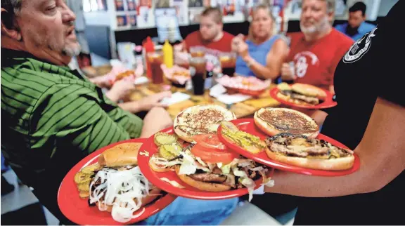  ?? BRYAN TERRY/THE OKLAHOMAN ?? Customers are served lunch Aug. 4, 2021, inside Sid’s Diner in El Reno, Oklahoma.