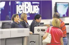  ?? Chris O’Meara / Associated Press 2016 ?? JetBlue Airways ticket agents assist passengers in Tampa. The airline is among the companies providing bonuses.