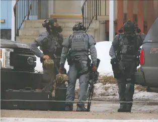  ?? JIM WELLS ?? Police tactical team members work at the scene of a weapons call in Penbrooke Meadows in southeast Calgary on Thursday. Police were executing a search warrant when shots were fired in their direction.