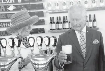  ?? PAUL CHIASSON/THE CANADIAN PRESS ?? Britain’s Prince Charles and Camilla, Duchess of Cornwall, react to a bad pour of beer the prince made on Tuesday at the Quidi Vidi Brewery in Quidi Vidi, a village in St. John’s, Newfoundla­nd. The visit came at the start of the couple’s three-day Canadian tour marking the 70th anniversar­y of Queen Elizabeth II’s ascent to the throne.