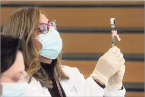  ?? Ned Gerard / Hearst Connecticu­t Media ?? Gina Christakos fills a syringe with COVID-19 vaccine at Hartford HealthCare’s mass vaccinatio­n clinic on the west campus of Sacred Heart University in Fairfield on March 10.