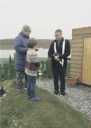  ??  ?? 0 Priest Ambrose Flavell with local residents after the blessing of the new chapel on Yell