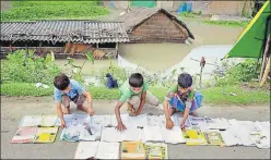  ?? PTI ?? Students lay their books on the road to dry in floodaffec­ted Morigaon, Assam, on Wednesday.