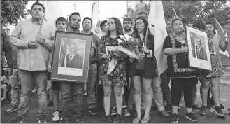  ?? DIEGO REYES VIELMA / REUTERS ?? People gather at the headquarte­rs of the National Renewal party in Santiago on Tuesday, mourning Chile’s former president Sebastian Pinera who died in a helicopter crash.