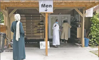  ?? (AP/Karen Ducey) ?? Shukri Olow (left) gets a thumbs-up as she greets worshipper­s outside the Islamic Center of Kent in Kent, Wash., south of Seattle.