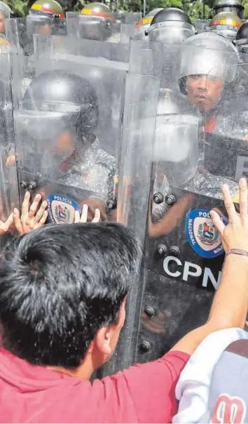  ?? EFE ?? Un grupo de jóvenes protestan ante la Policía Nacional Bolivarian­a