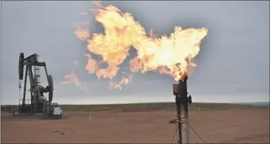  ?? Matthew Brown Associated Press ?? A FLARE burns natural gas last year at an oil well in Watford City, N.D.