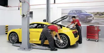  ??  ?? Audi technician­s work on an Audi R8 supercar