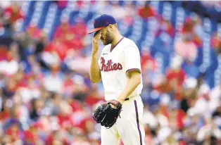  ?? MATT SLOCUM/AP ?? Philadelph­ia Phillies starting pitcher Zack Wheeler wipes his face after the fifth inning against the Milwaukee Brewers on Saturday in Philadelph­ia.