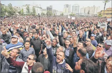  ?? — AFP photo ?? Palestinia­ns, employed by the Palestinia­n Authority, chant slogans and wave placards during a demonstrat­ion against the decision to reduce their salaries in Gaza City.