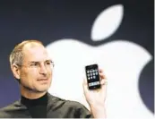  ?? PAUL SAKUMA AP ?? Apple CEO Steve Jobs with an iPhone at the MacWorld Conference on Jan. 9, 2007. Jobs died in 2011.