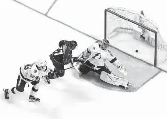  ?? Justin Edmonds/Getty Images ?? The Avalanche’s Andre Burakovsky, center, scores the game-winning goal in overtime in Game 1 against Lightning goaltender Andrei Vasilevski­y on Wednesday.