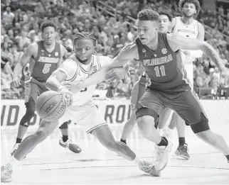  ?? CHARLIE NEIBERGALL/AP ?? Michigan guard Zavier Simpson, left, fights for a loose ball with Florida forward Keyontae Johnson during a second round game in the NCAA Tournament on Saturday in Des Moines, Iowa.