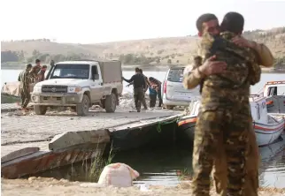  ??  ?? Members of the Syrian Democratic Forces (SDF) stand on a boat at Lake Assad, an enormous reservoir created by the Tabqa dam, on Saturday. (AFP)