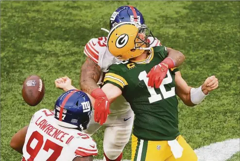  ?? Mike Hewitt / Getty Images ?? The Green Bay Packers’ Aaron Rodgers (12) is sacked by the Giants’ Oshane Ximines and fumbles the ball in the fourth quarter Sunday at Tottenham Hotspur Stadium in London.