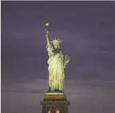  ?? Spencer Platt / Getty Images ?? The Statue of Liberty stands in New York Harbor as a welcoming symbol to generation­s of immigrants.