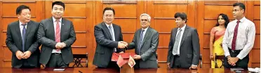  ??  ?? Treasury Secretary Dr. R.H.S. Samaratung­a and Chinese Ambassador Cheng Xueyuan exchanging the loan agreement in the presence of Finance Ministry and Chinese Embassy officials