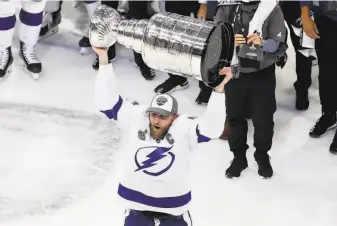  ?? Bruce Bennett / Getty Images ?? Center Steven Stamkos, who missed all but one of the Lightning’s 16 postseason games in the bubble, skates with the Stanley Cup after the seriesclin­ching victory over the Dallas Stars.