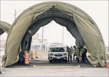  ?? Paul Chiasson / Associated Press ?? Passengers are screened and receive a COVID test upon entering Canada from the United States at the border in Saint-bernardde-lacolle, Quebec.