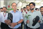  ?? BURHAAN KINU/HT PHOTO ?? Members of Aam Aadmi Sena hold slippers and rose as they wait for Ravindra Gaikwad to arrive at IGI airport, in New Delhi, on Friday.