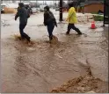  ?? SHMUEL THALER — SANTA CRUZ SENTINEL ?? A trio brave the flood on East Lake Avenue in Watsonvill­e on Monday to check on family members isolated in their home along Corralitos Creek.