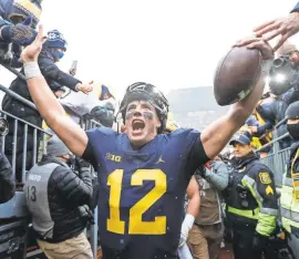  ?? JUNFU HAN/DETROIT FREE PRESS ?? Michigan quarterbac­k Cade McNamara celebrates with fans as he walks up the tunnel after the Wolverines’ 42-27 win.