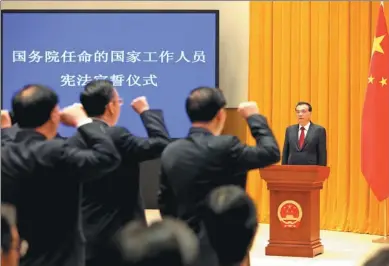  ?? WU ZHIYI / CHINA DAILY ?? Premier Li Keqiang oversees the swearing-in of 62 officials to 39 department­s under the State Council at the Zhongnanha­i leadership compound in Beijing on Monday.