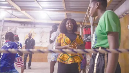  ?? Photo: Nampa/AFP ?? Attentive… Sarah Lotus Asare (second left), a volunteer who works with disadvanta­ged teenage girls, interacts with a girl in a boxing gym in James Town, Accra.