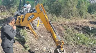  ?? CONTRIBUTE­D PHOTOS ?? Alando Terrelonge observes the drain cleaning and community developmen­t in Silverston­e, Portmore.